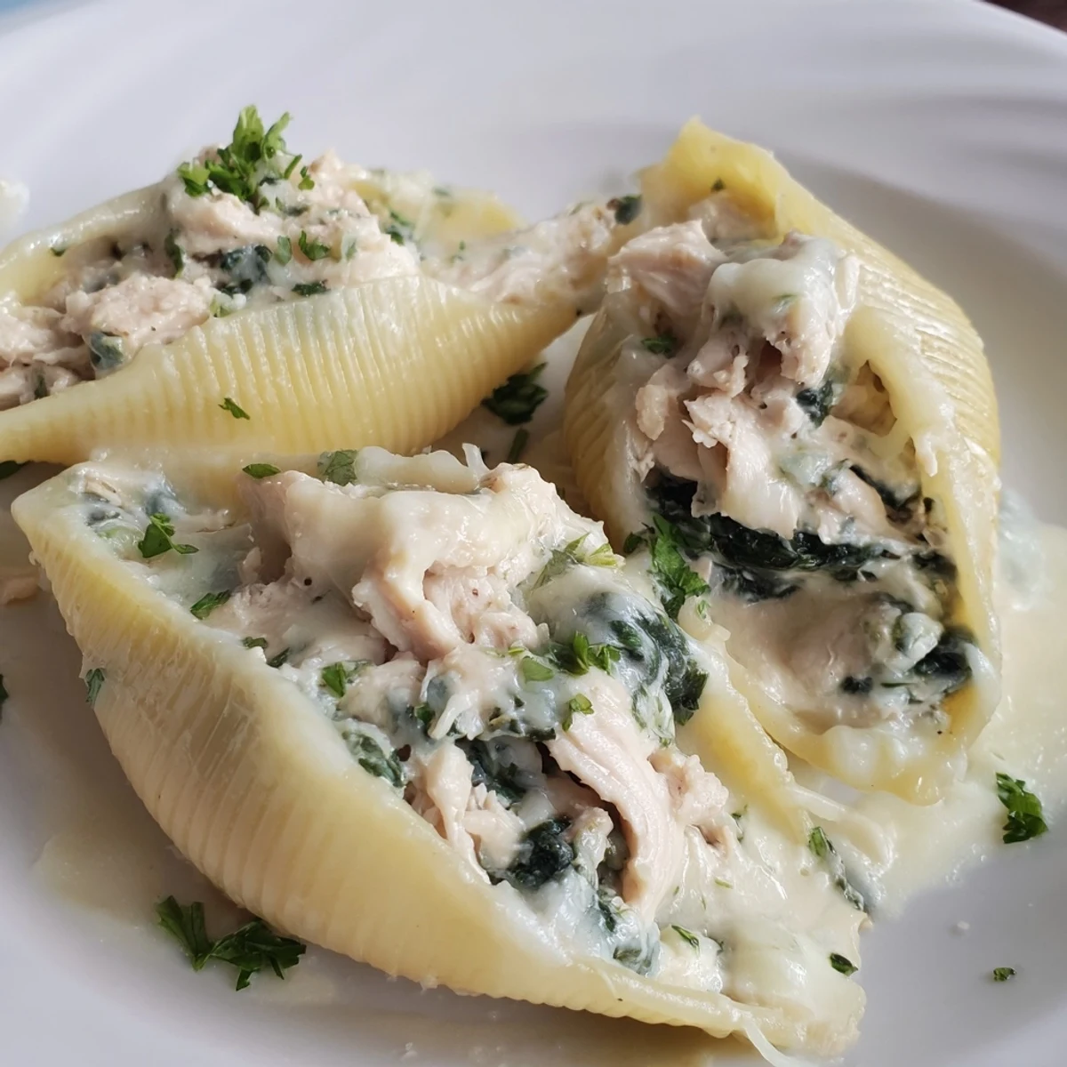 A close-up of creamy Chicken Alfredo Stuffed Shells with Spinach, featuring tender pasta filled with ricotta and spinach.  