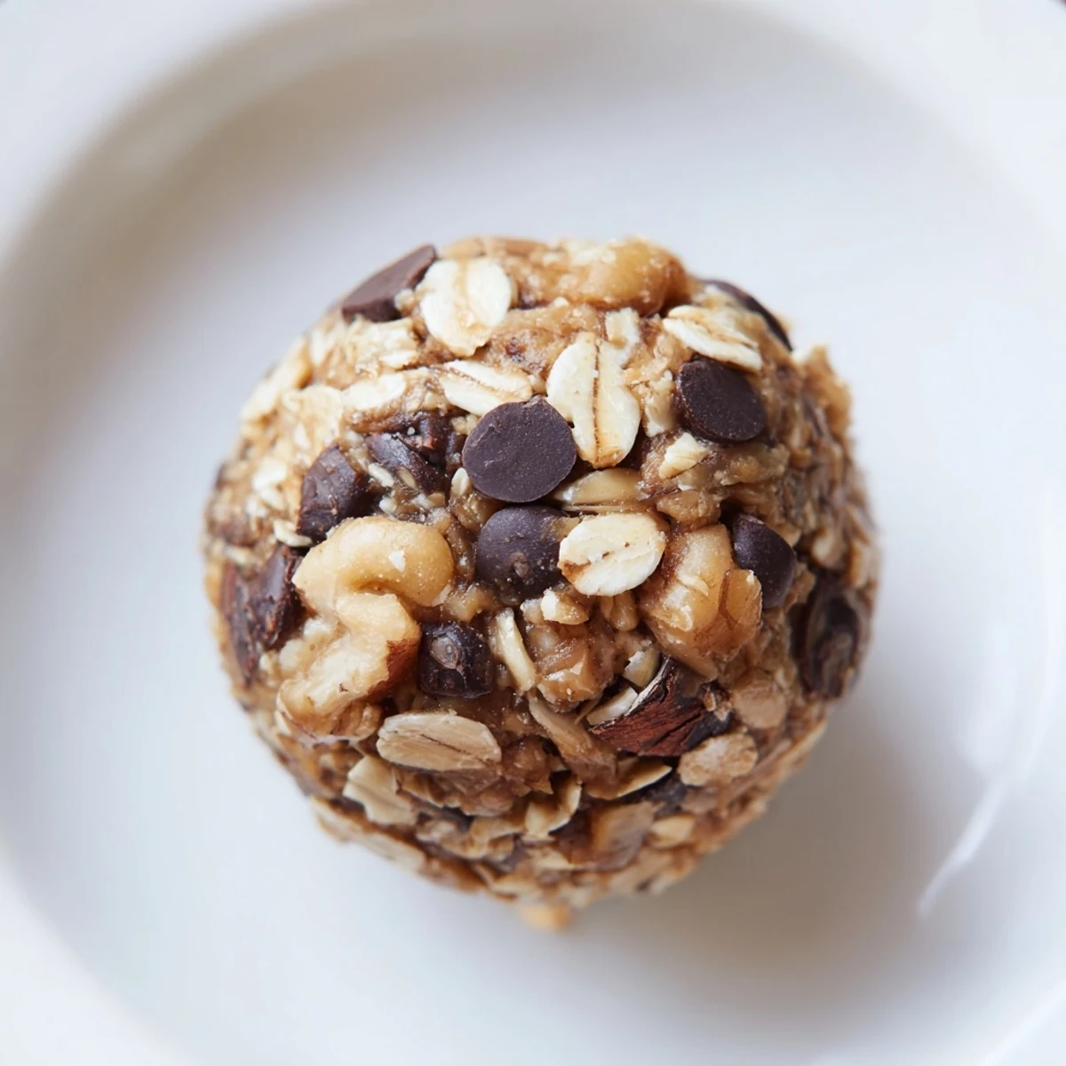 Chocolate Peanut Butter Energy Balls arranged on a white plate, showing rich cocoa coating and melted dark chocolate chips for a quick snack.  