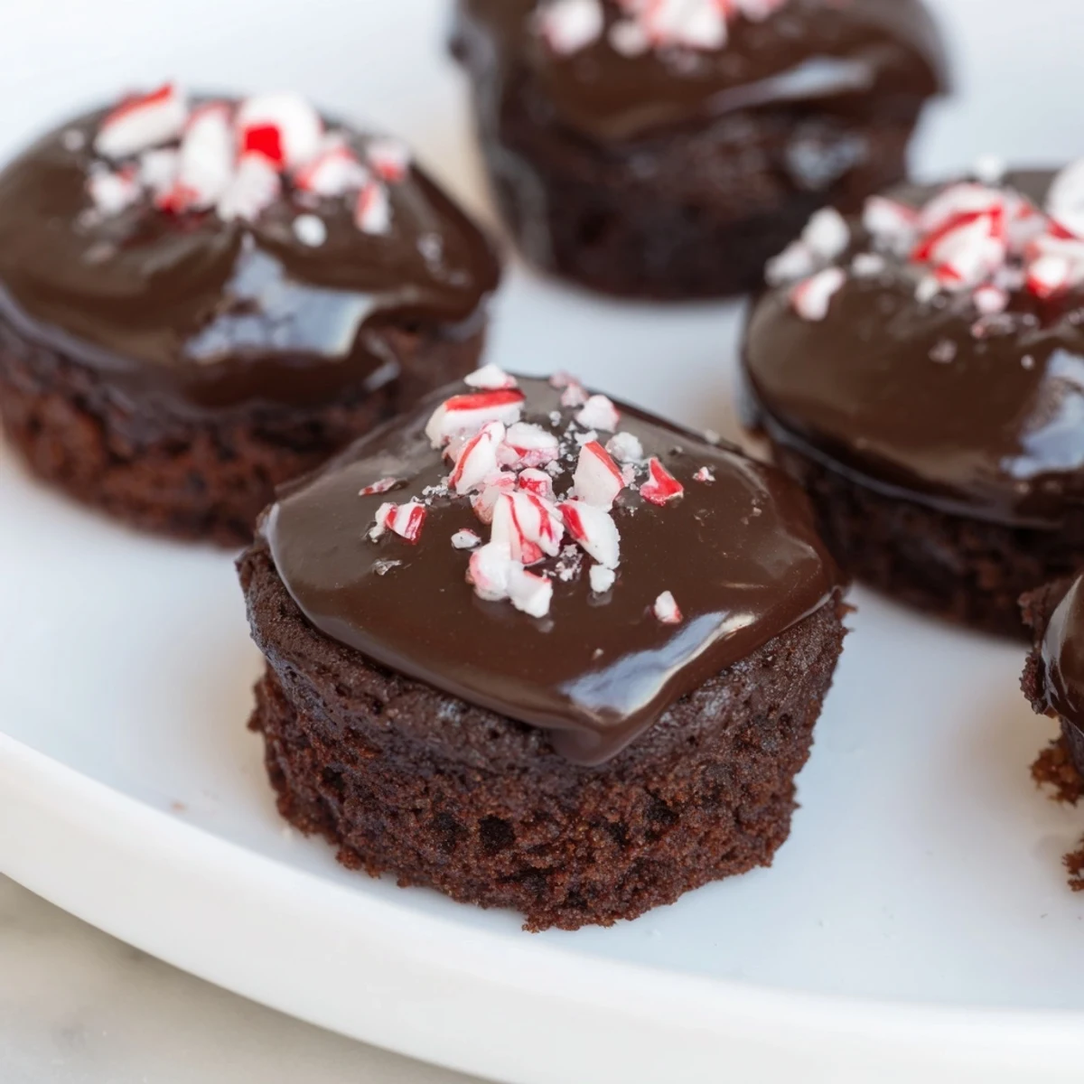 Freshly baked Mint Brownie Bites are stacked on a wire rack, ready for dessert.