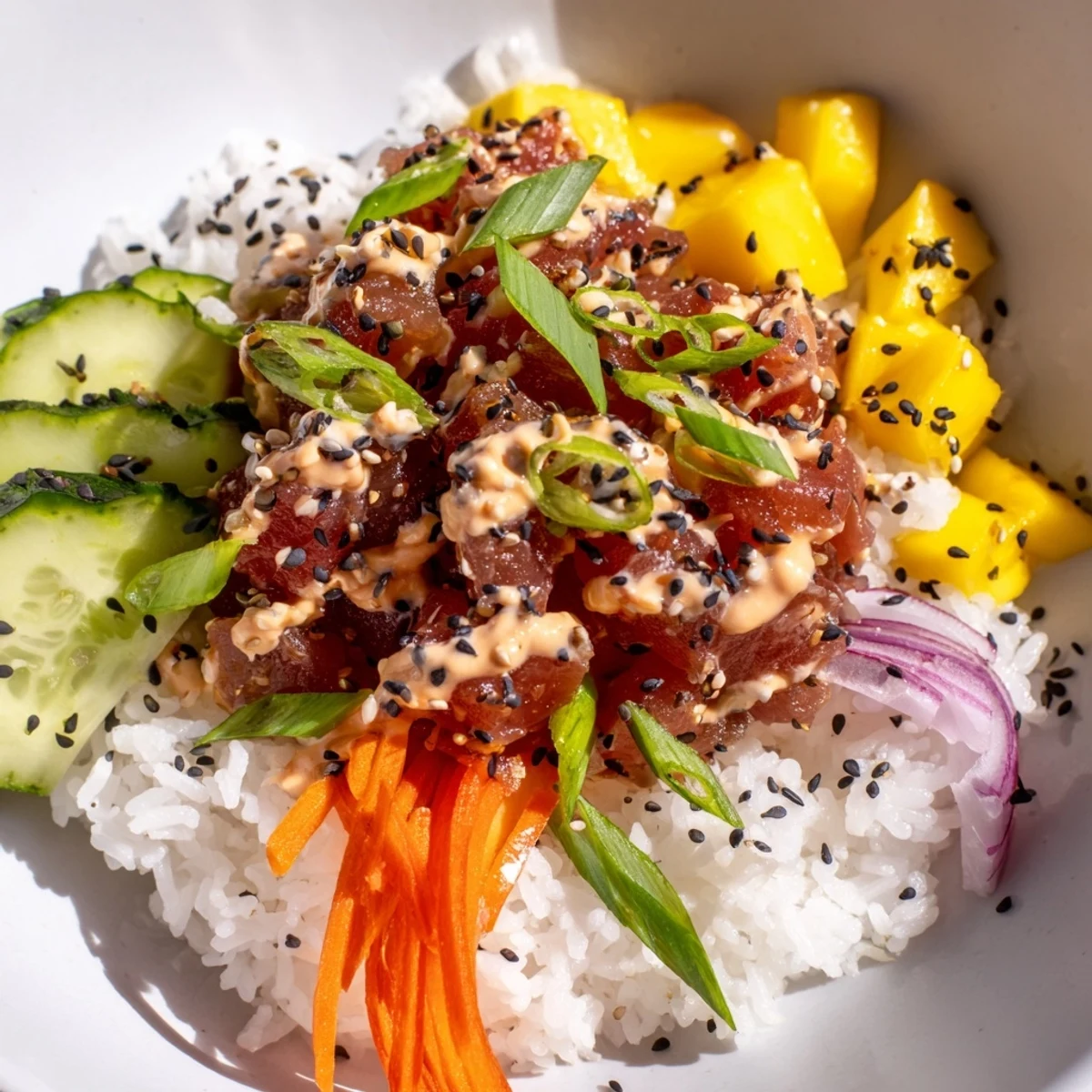 Bright spicy tuna poke bowl with mango showcases marinated tuna, creamy sauce, sweet mango, crisp veggies, and sesame seeds over fluffy sushi rice.