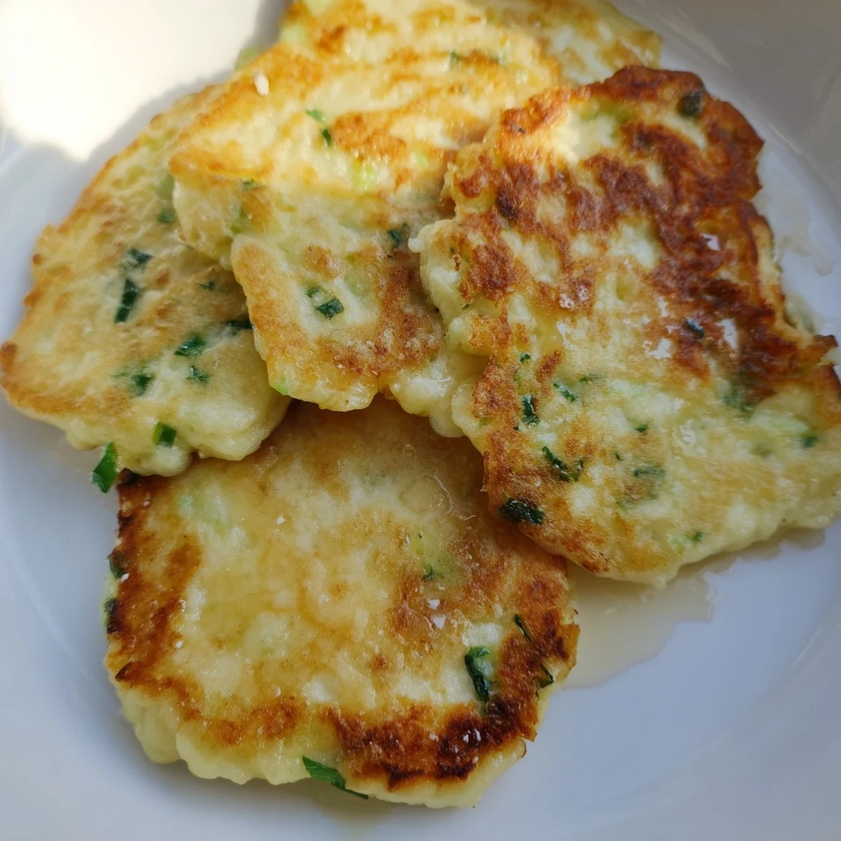Rustic Irish Boxty Potato Pancakes with Scallions rest on a wooden board beside poached eggs and smoked salmon, highlighting this traditional Irish comfort food.