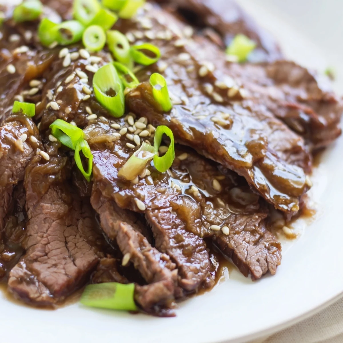 A slow cooker filled with Ultimate Slow Cooker Mongolian Beef, featuring tender beef pieces coated in rich savory-sweet sauce.