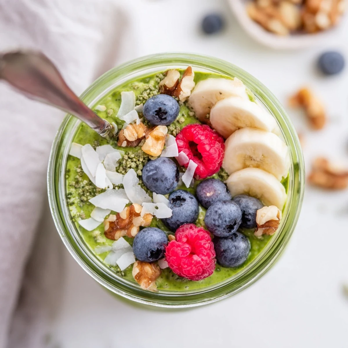 A top-down view of Matcha Protein Overnight Oats with sliced bananas and nuts, perfect for a high-protein morning meal.