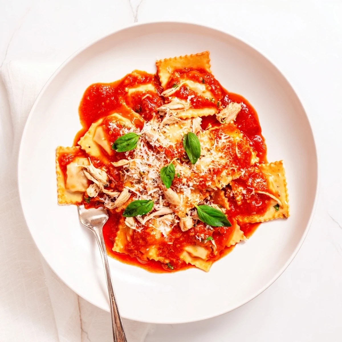 Overhead view of homemade Chicken and Mushroom Ravioli with Simple Tomato Sauce, garnished with fresh basil and ready to be enjoyed.
