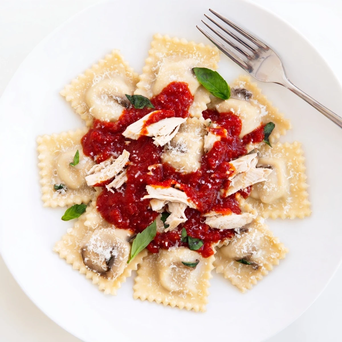 A cozy serving of Chicken and Mushroom Ravioli with Simple Tomato Sauce, glistening with olive oil and herbs in a ceramic bowl.
