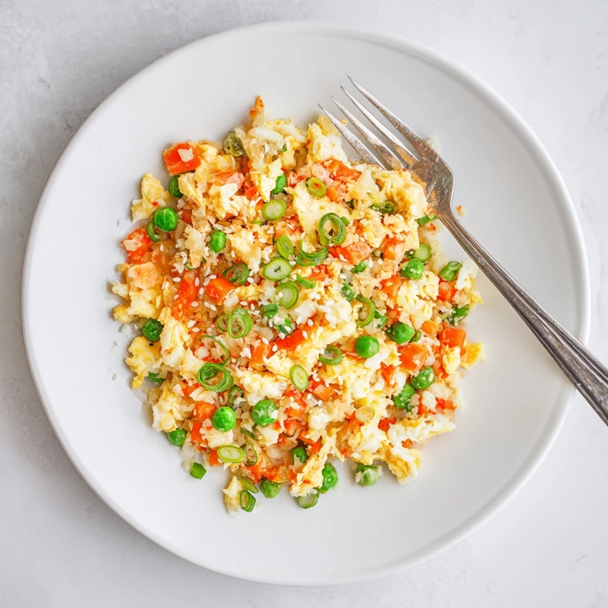 Golden cauliflower rice sizzles in a skillet with spicy kimchi and scrambled eggs in this Cauliflower Fried Rice with Kimchi and Eggs.