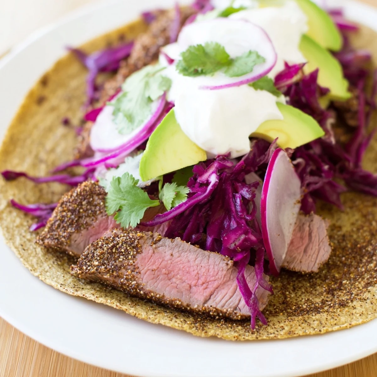 Fusion lamb tacos featuring aromatic cumin crusted meat with zesty lime and sour cream