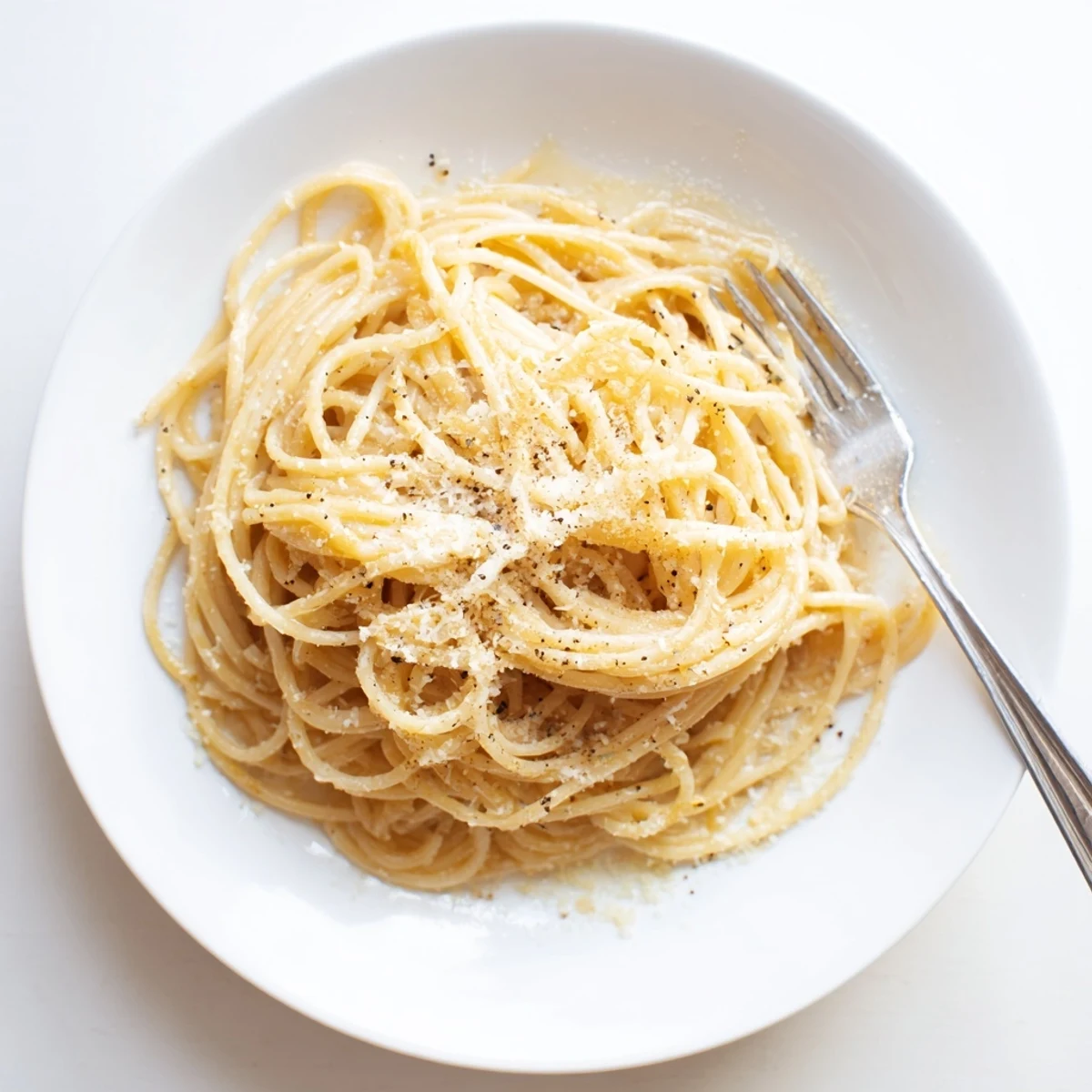 Twirled spaghetti tossed in glossy cheese sauce topped with freshly ground black pepper and extra Pecorino