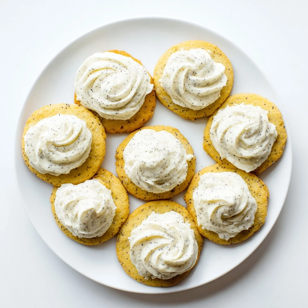 Soft buttery lemon poppy seed cookies with thick tangy cheesecake frosting swirls