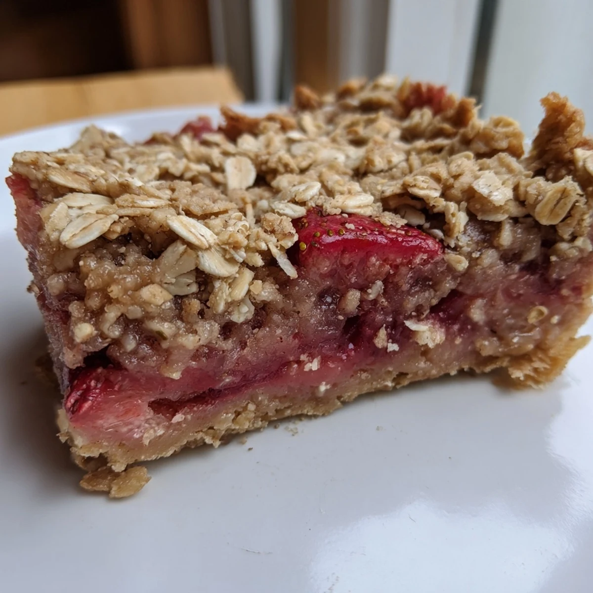 Fresh baked strawberry oatmeal crumble bars sliced into squares with sweet red strawberry layer