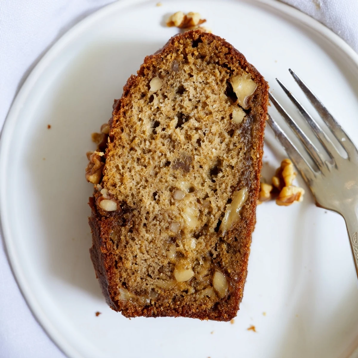 Golden brown moist banana bread loaf with a tender crumb, sliced on a wooden cutting board