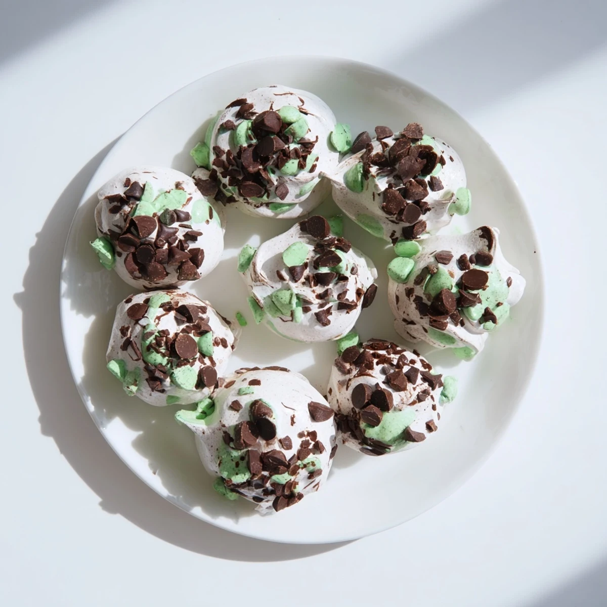 Dreamy dark chocolate and mint chip clouds recipe showing light airy meringue mounds dotted with dark chocolate pieces and bright mint chips