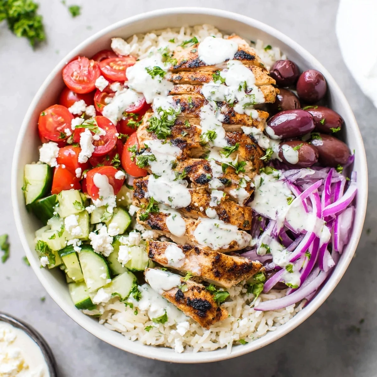 Protein-packed Greek chicken bowls featuring tender chicken fluffy rice and tangy yogurt drizzle with fresh parsley