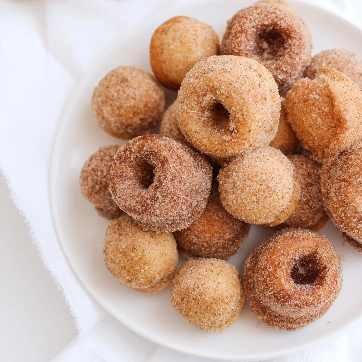 Pillowy biscuit donuts tossed in pumpkin cinnamon sugar coating ready for serving