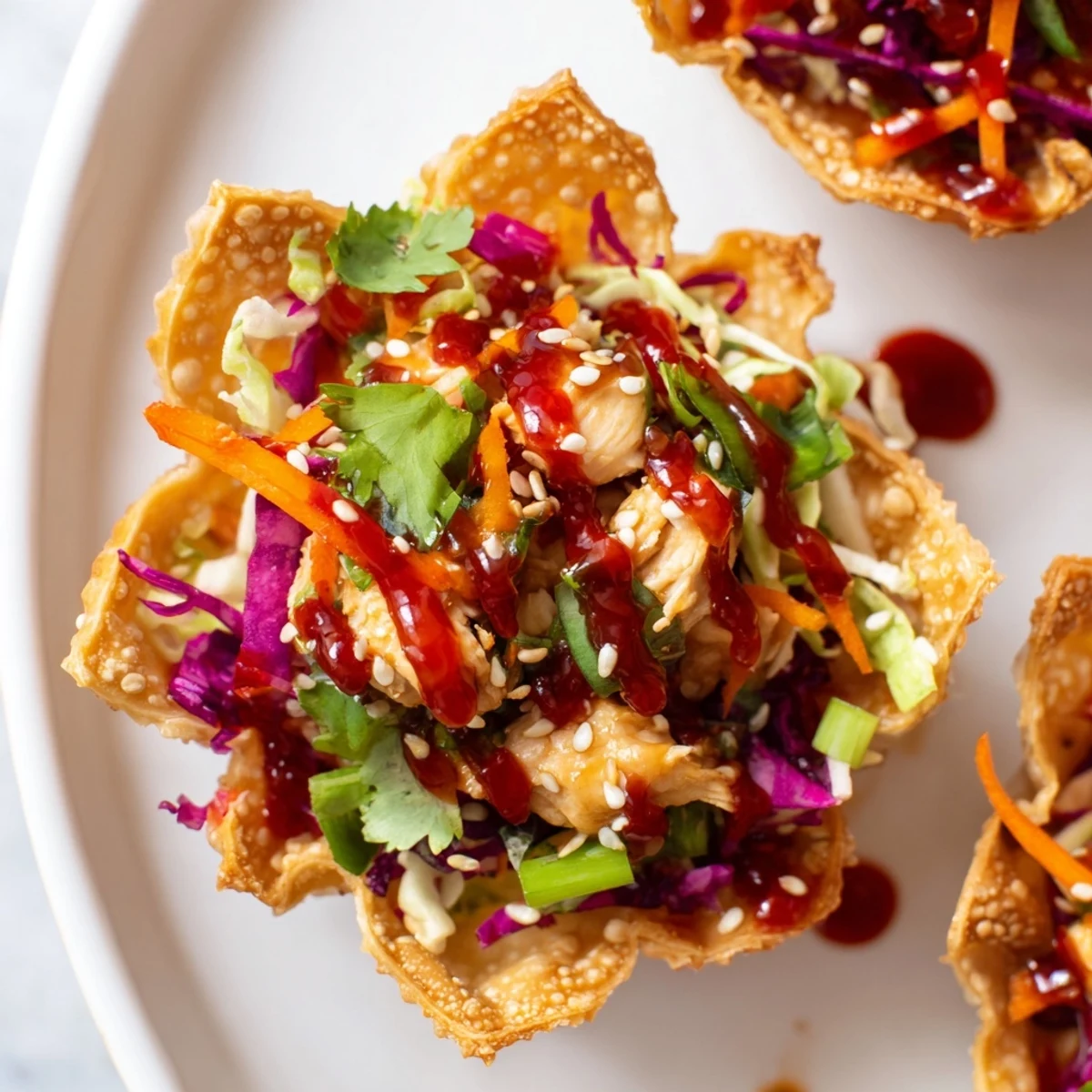 Golden crispy chicken wonton tacos topped with colorful Asian slaw and drizzled with sweet chili sauce