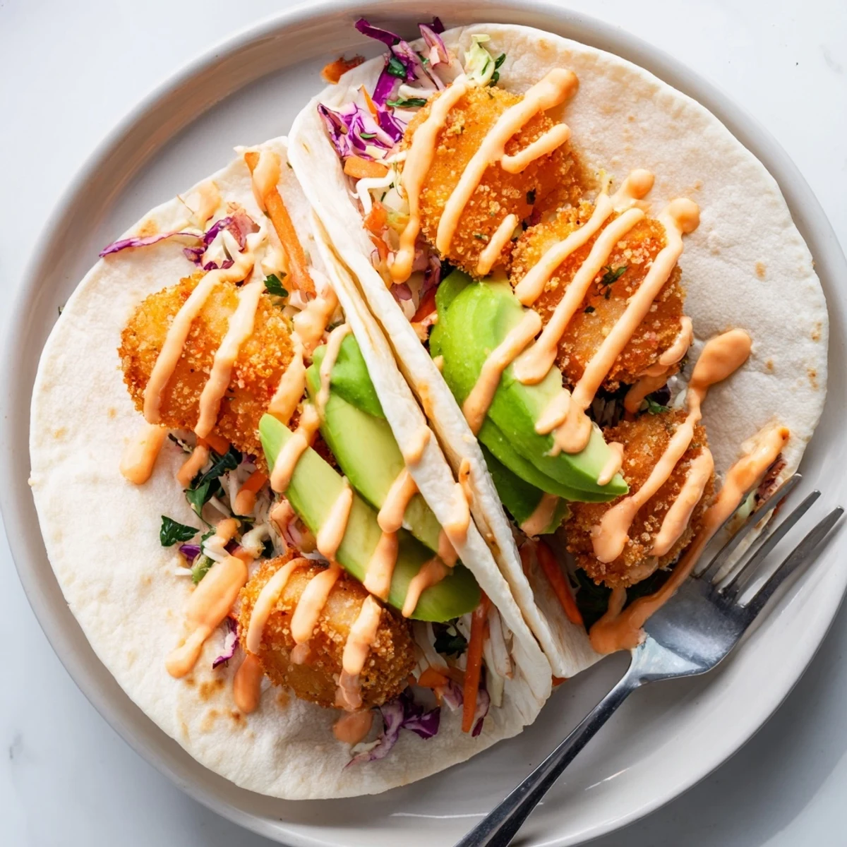 Golden fried shrimp coated in sweet and spicy Bang Bang sauce served in soft tacos with fresh avocado slices