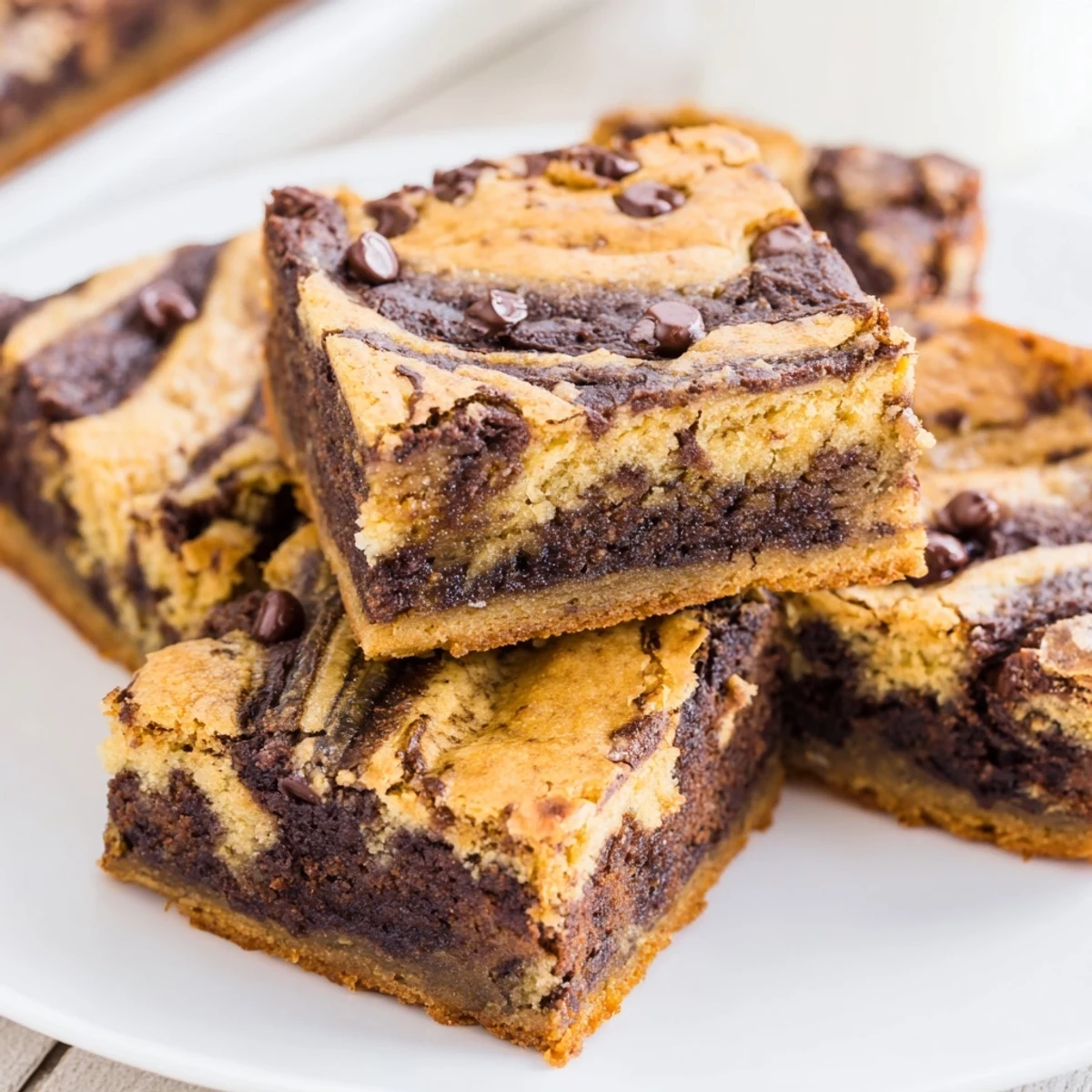Freshly baked banana bread brownie bars showing marbled swirls of chocolate and banana layers on a wooden cutting board