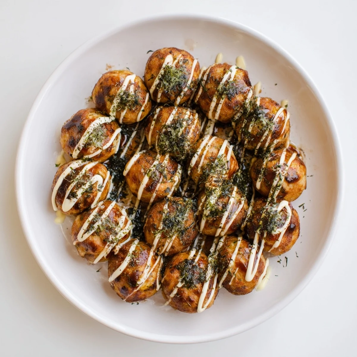 Crispy exterior takoyaki filled with tender octopus pieces topped with tangy sauce and green onion