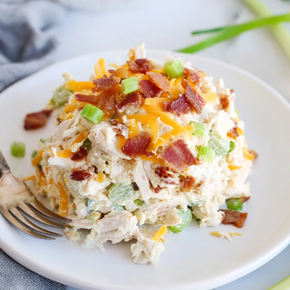 Creamy jalapeno popper keto chicken salad topped with crispy bacon crumbles in white bowl