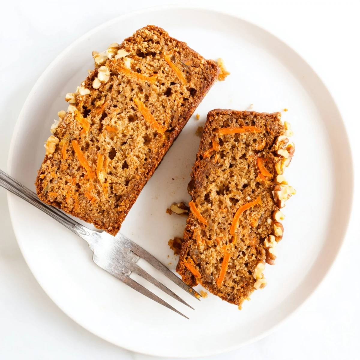 Freshly baked carrot cake banana bread with cream cheese frosting drizzle, showing tender crumb texture