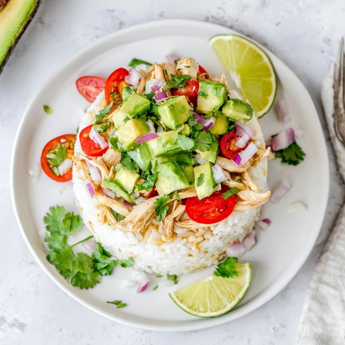 Golden honey lime chicken stacked over fluffy rice with creamy avocado slices and fresh cilantro garnish