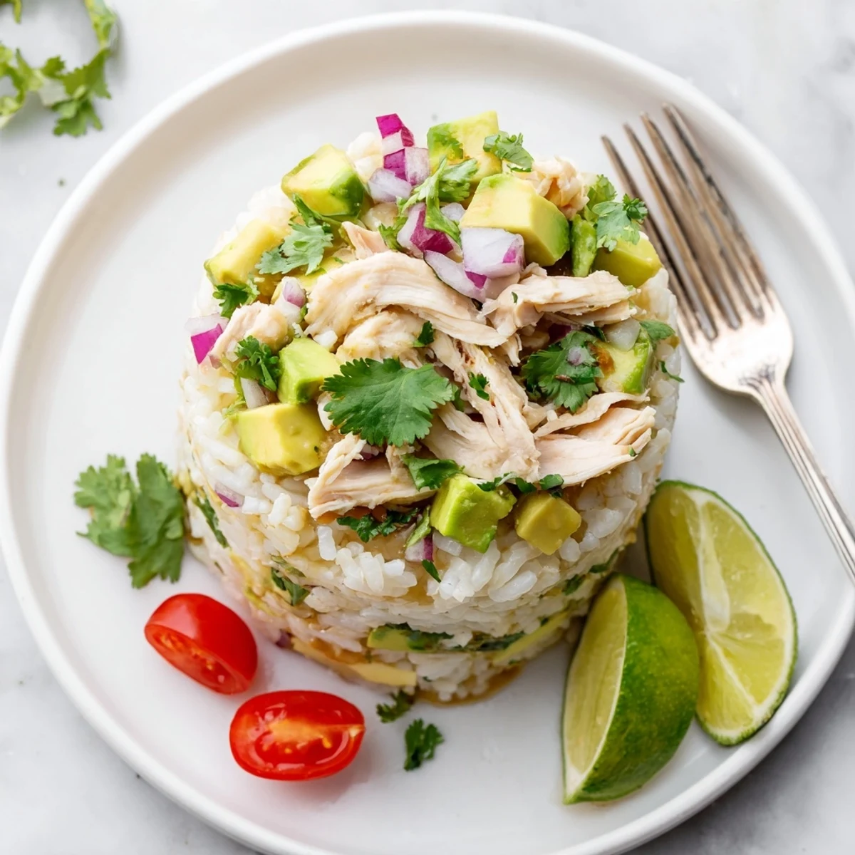 Vibrant rice stack bowl topped with sliced honey lime chicken breast, diced avocado, red onion, and cherry tomatoes