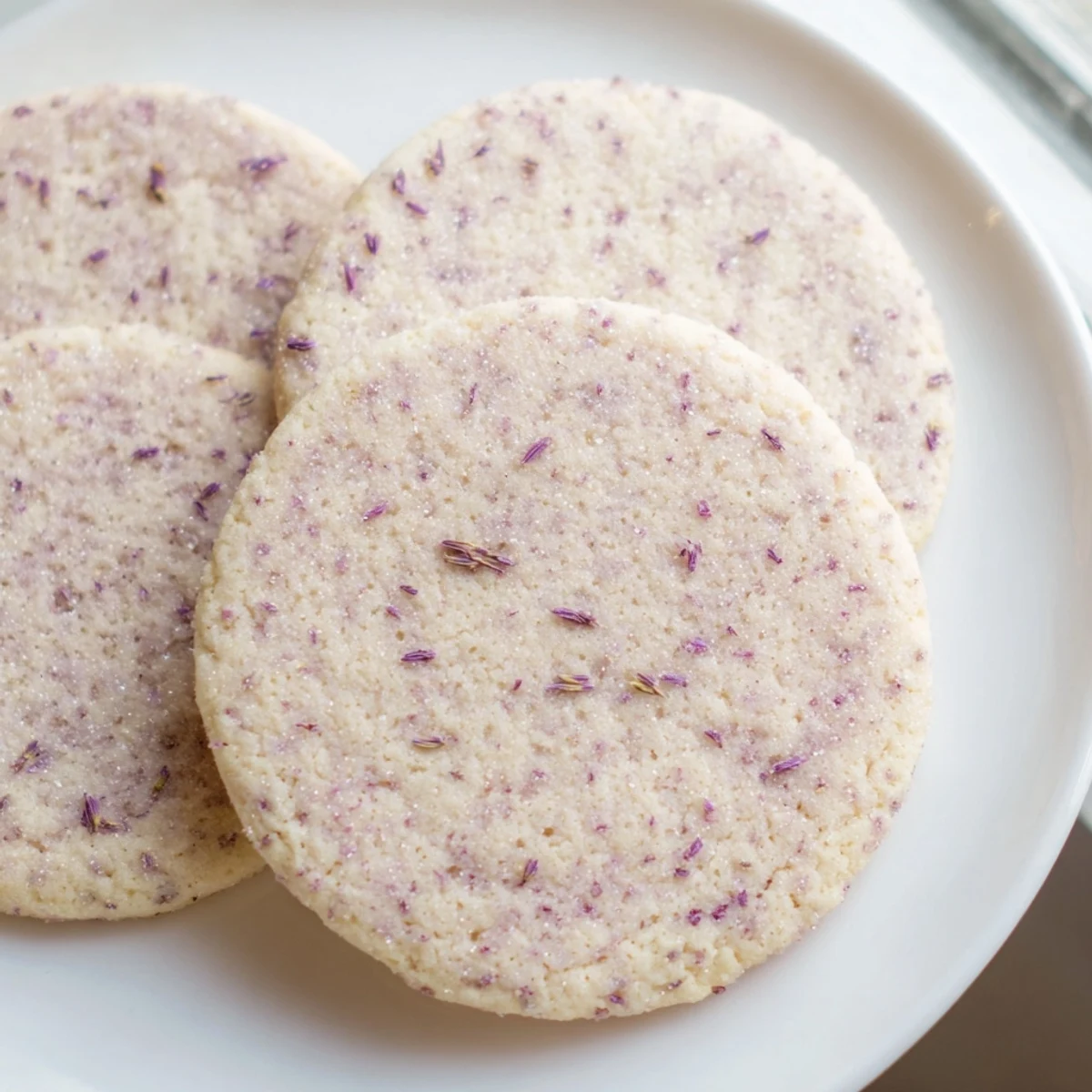 Buttery lilac sugar cookies with golden edges cooling on a wire rack