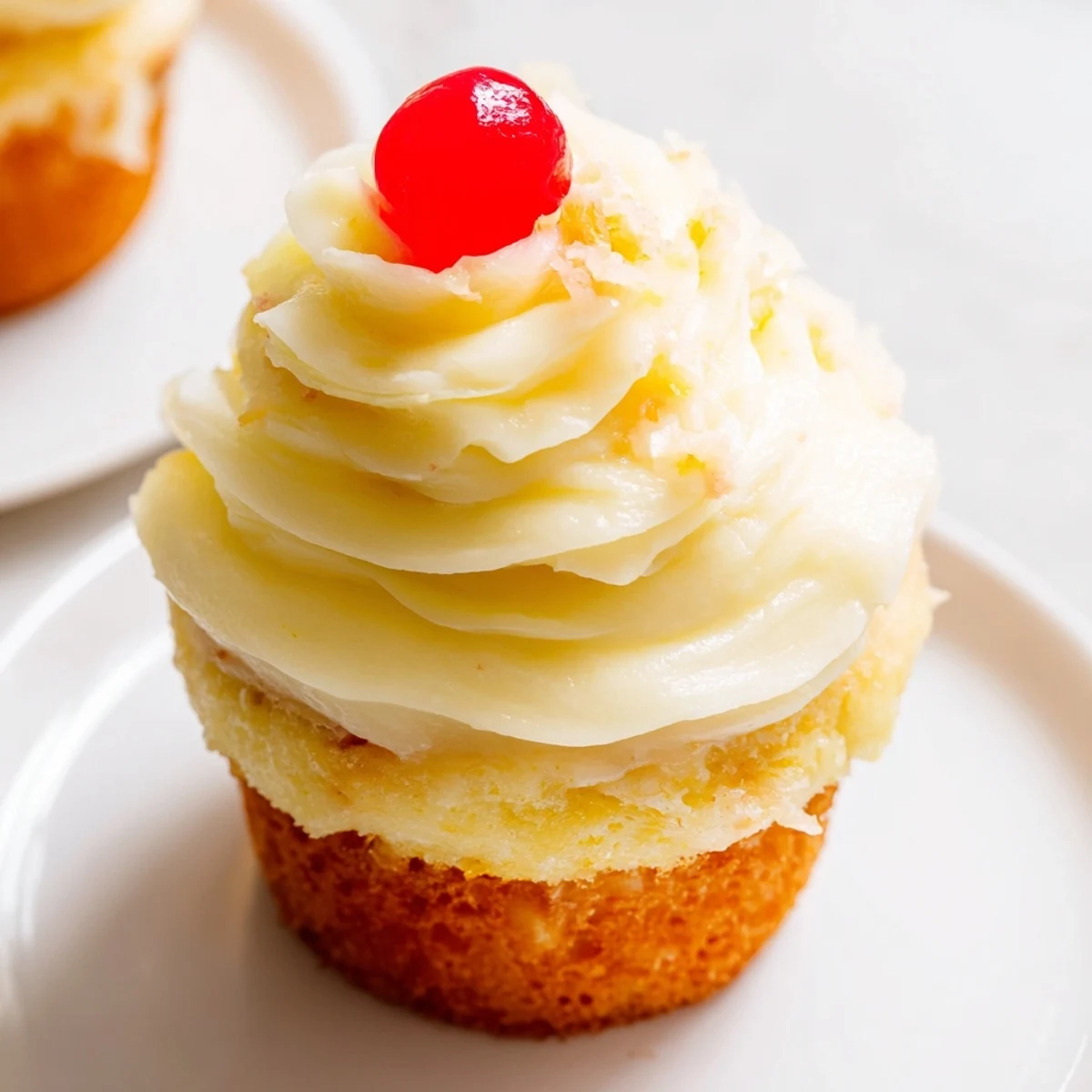 A batch of Dole Whip Cupcakes garnished with pineapple wedges on a wire rack