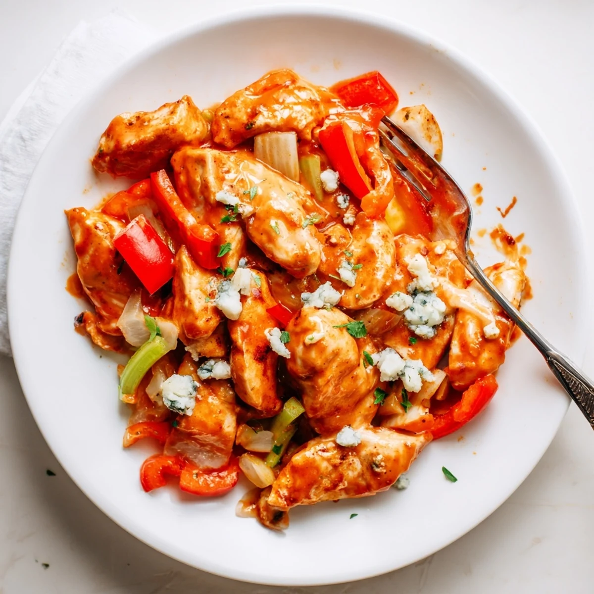 Keto Buffalo Chicken Skillet topped with crumbled blue cheese and fresh parsley