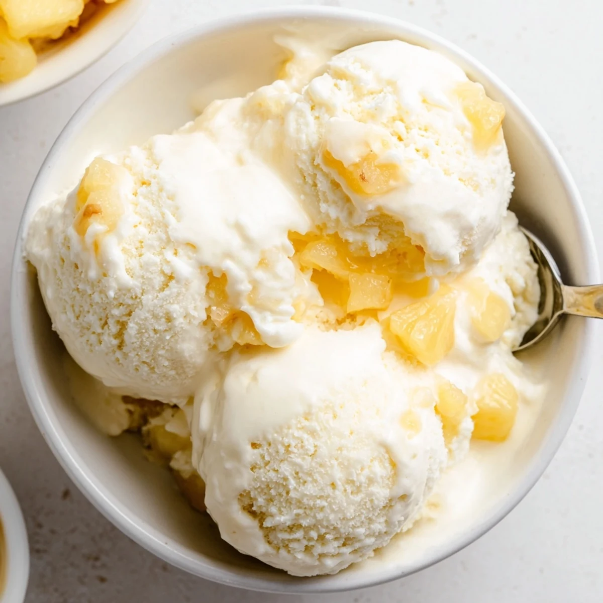 Chilled bowl of Creamy Pineapple Ice Cream Recipe garnished with toasted coconut