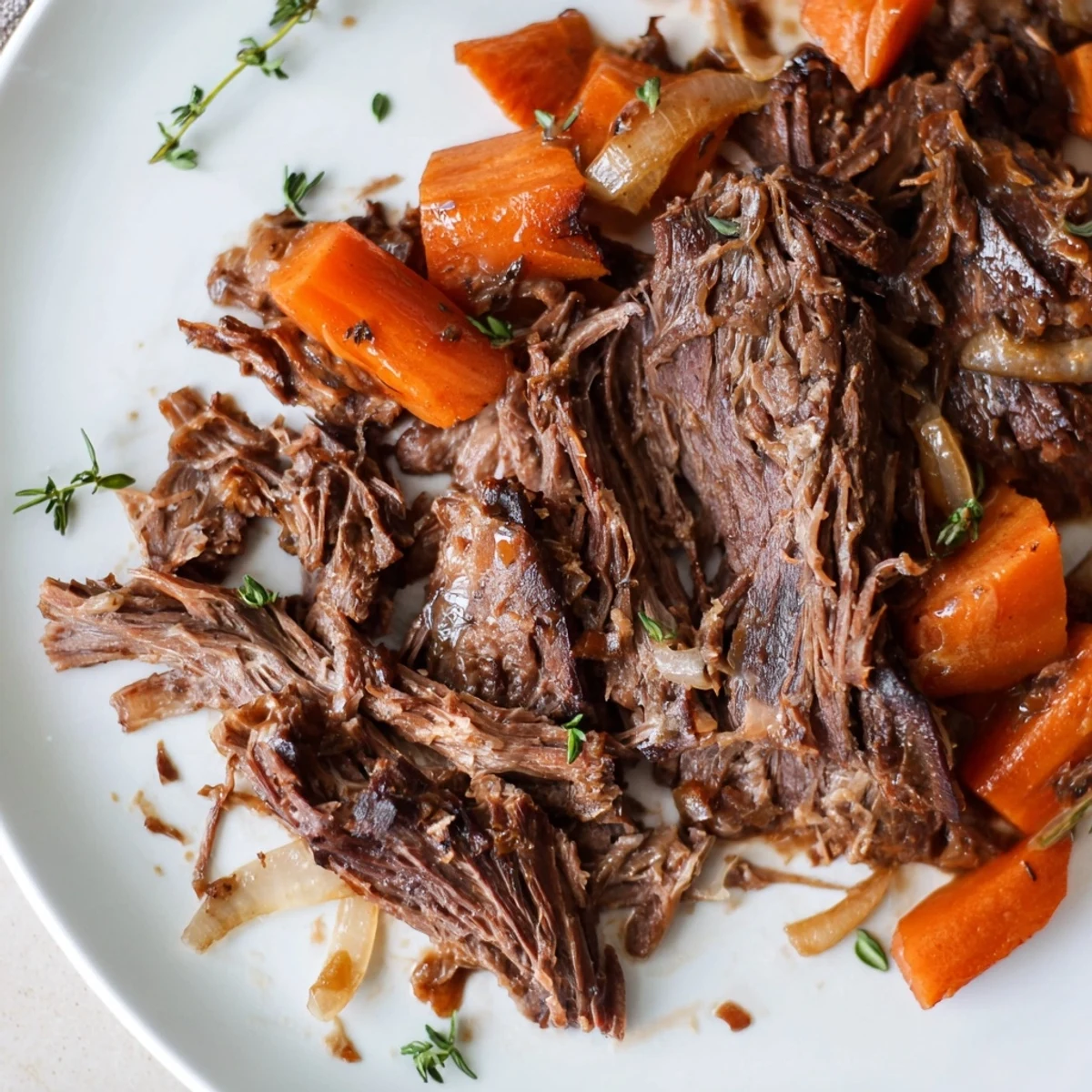 Herb braised beef chuck roast served tender with carrots and onions in rich sauce