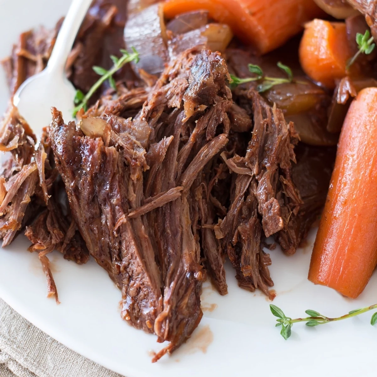 Slow-cooked herb braised beef chuck roast surrounded by braised vegetables and savory juices
