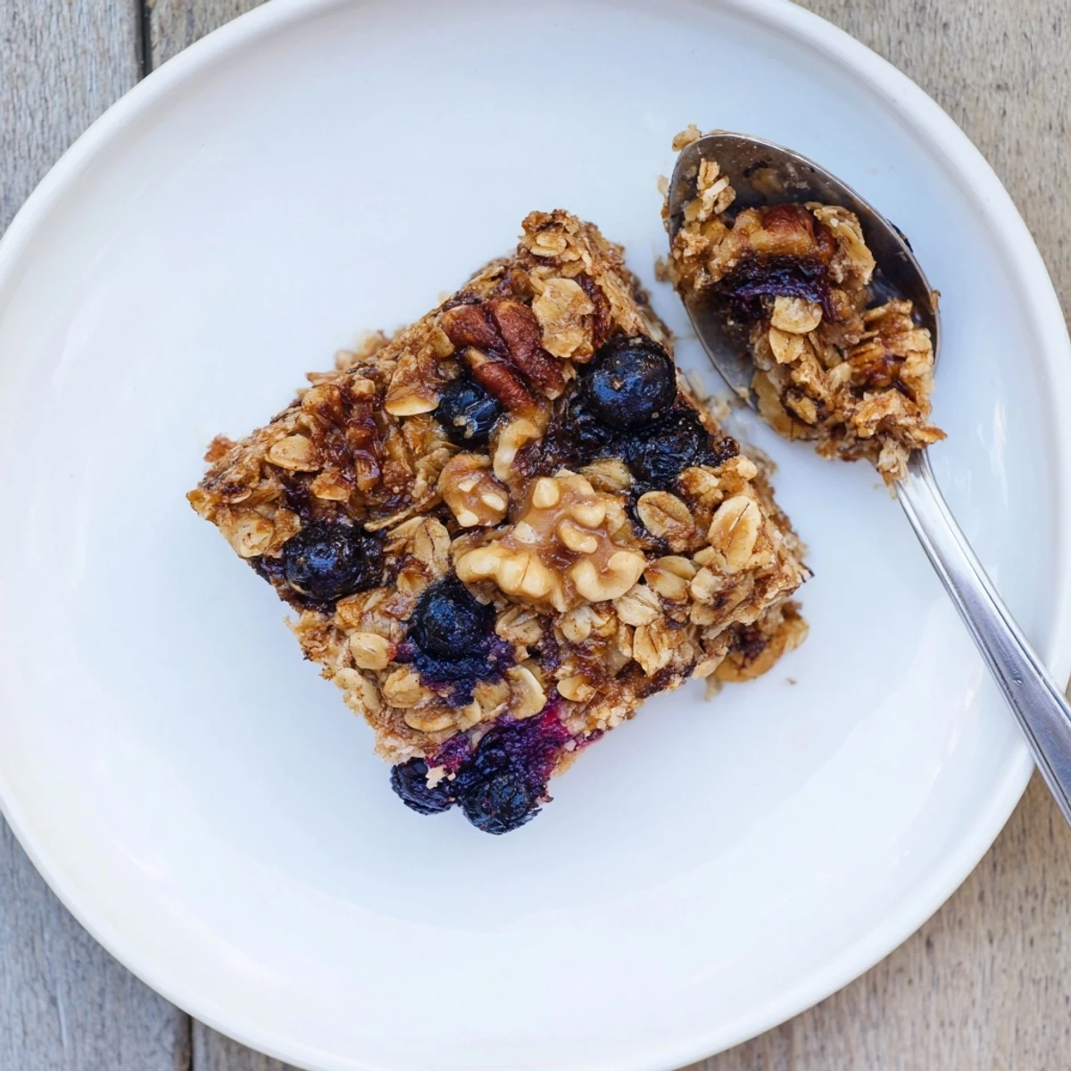 Golden baked oatmeal topped with fresh blueberries and a sprinkle of cinnamon