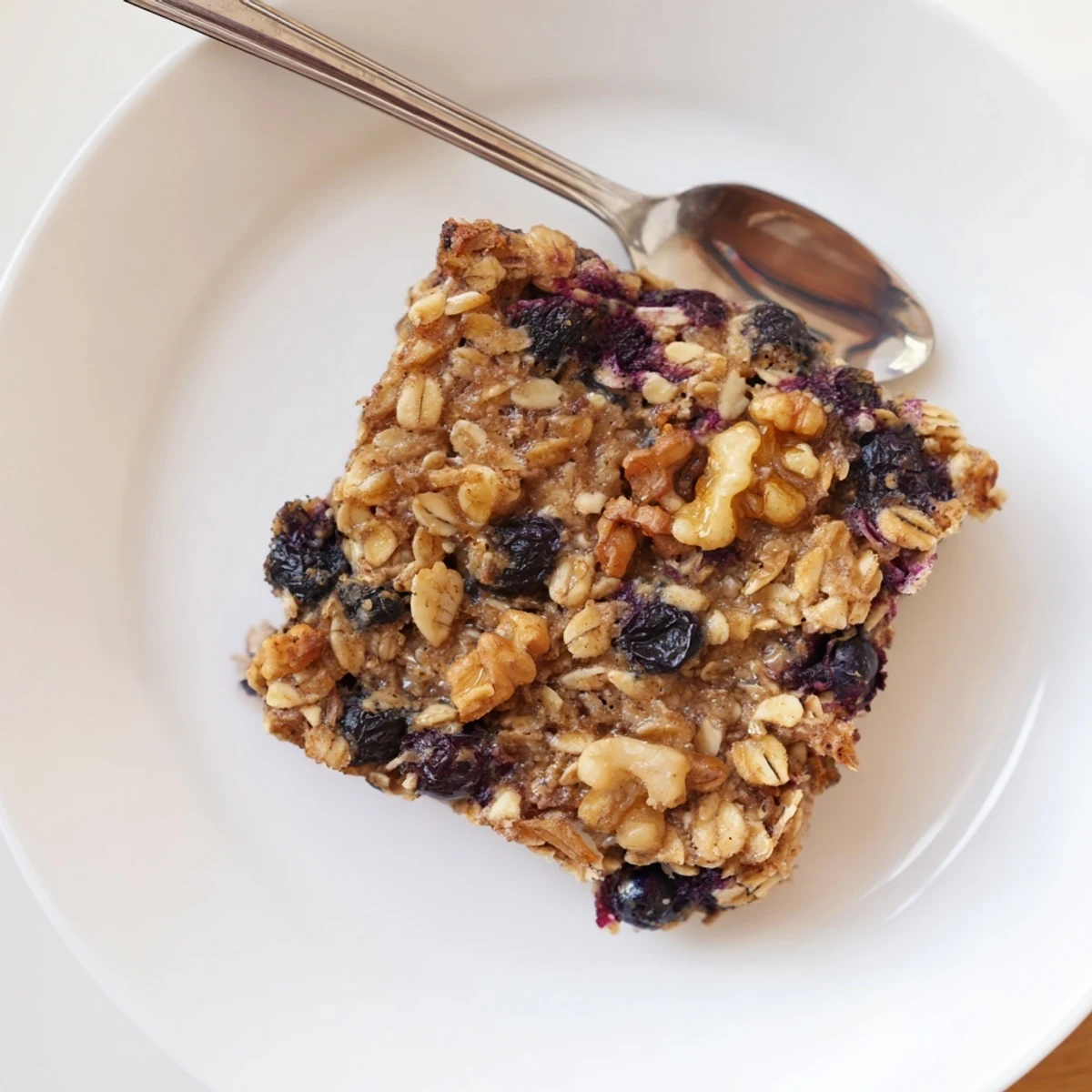 Comforting baked oatmeal dish served with milk and drizzled with maple syrup