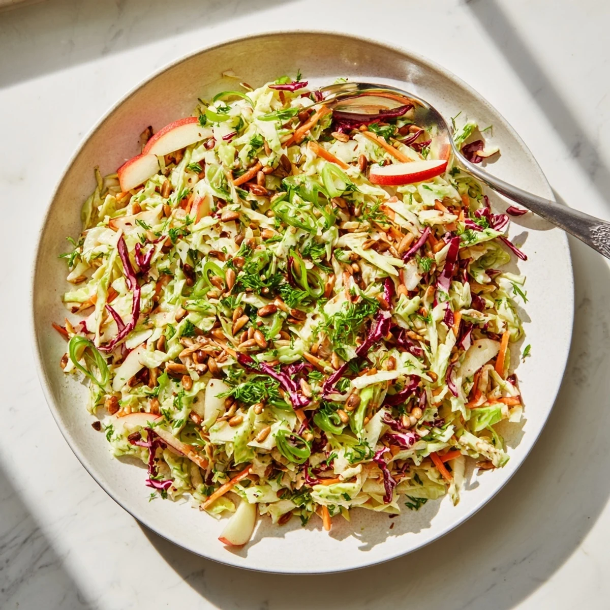Tangy apple coleslaw salad featuring colorful red and green cabbage with julienned apples