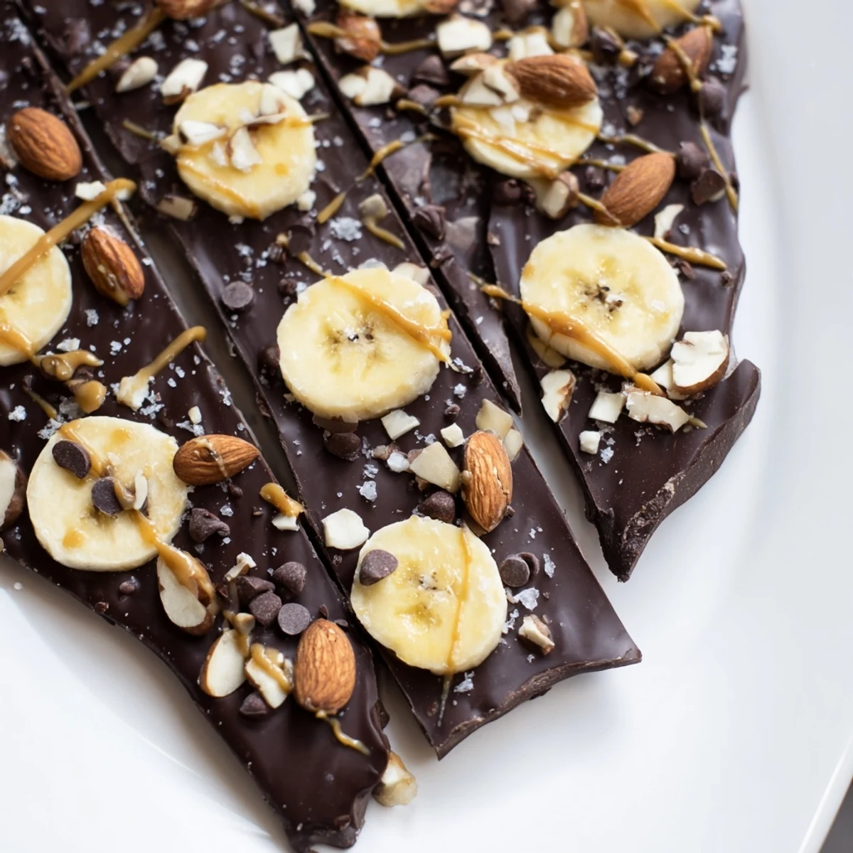 Glossy chocolate banana bark topped with crushed nuts and flaky sea salt