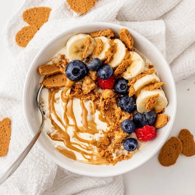 Quick Biscoff Overnight Oats served with sliced bananas and a spoon, ready for an easy breakfast.