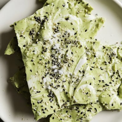 Perfectly set bark pieces showcase marbled matcha chocolate topped with crunchy black sesame seeds, ready for gifting or snacking.
