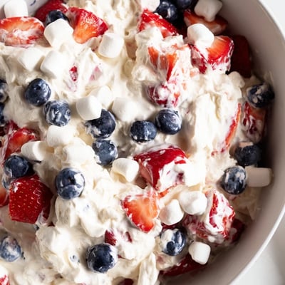 Red white blue cheesecake salad served chilled in a rustic white bowl